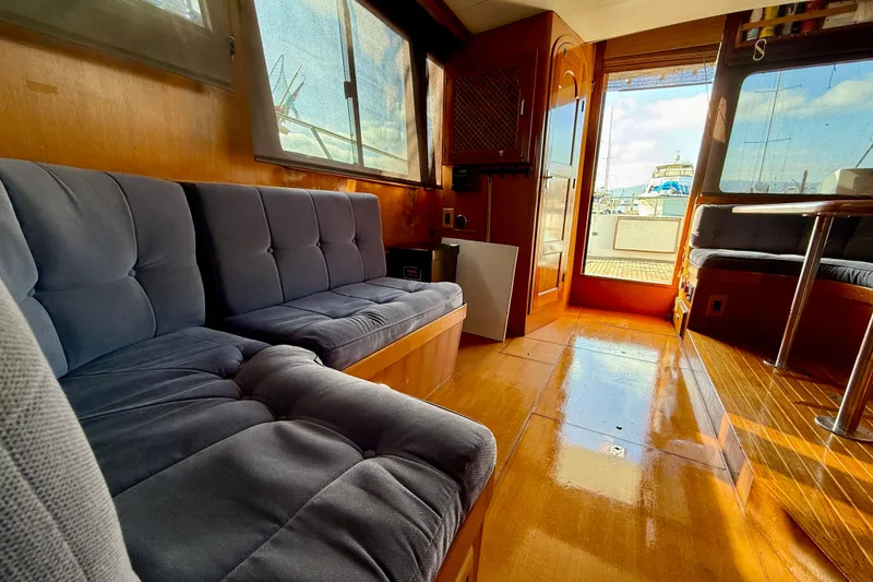 Slide: The Image of Interior of 1990 Mikelson 42 yacht with plush seating and wooden flooring. - 16