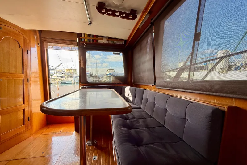 Slide: The Image of Interior of 1990 Mikelson 42 yacht with wooden finishes and cushioned seating. - 17