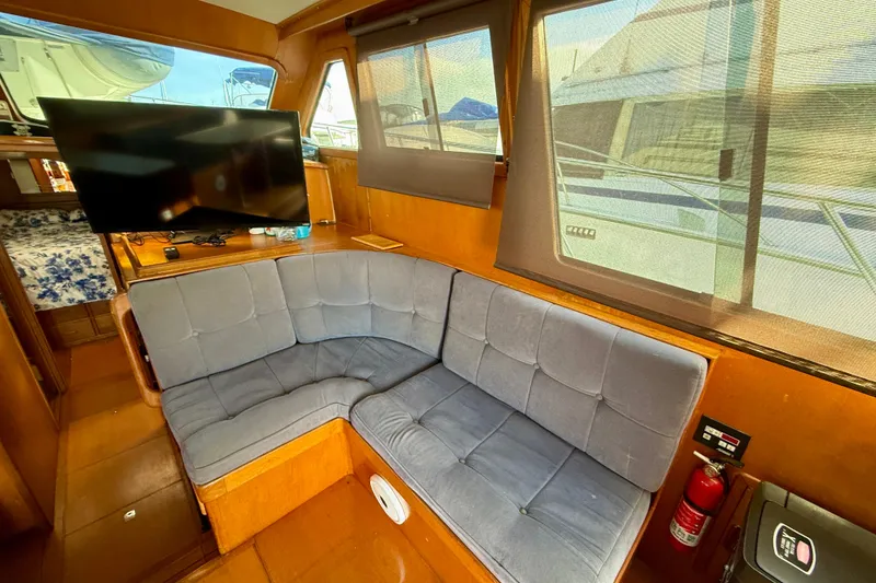 Slide: The Image of Interior of 1990 Mikelson 42 yacht with cozy seating and TV. - 18