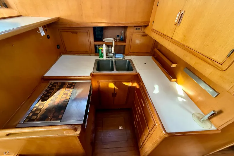 Slide: The Image of Compact wooden kitchen interior of 1990 Mikelson 42 boat with sink and stove. - 19