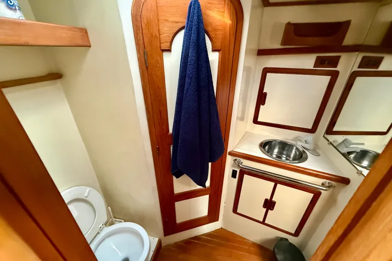 Slide: The Image of 1990 Mikelson 42 yacht bathroom with wooden accents and compact design. - 25
