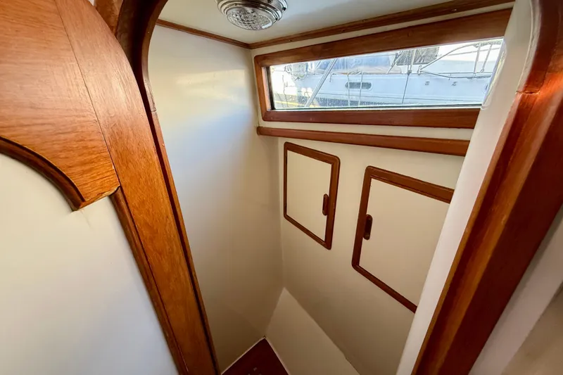 Slide: The Image of Interior of 1990 Mikelson 42 boat with wooden trim and storage cabinets. - 26