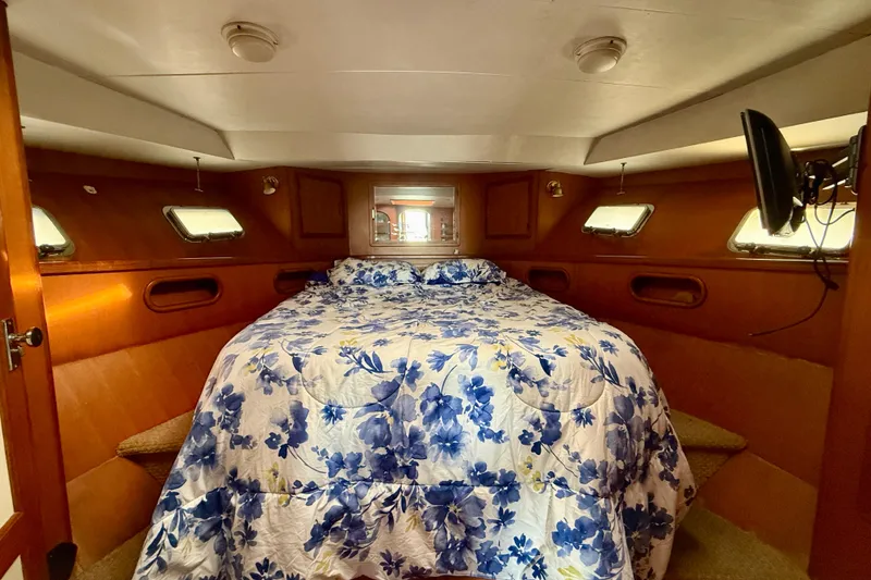 Slide: The Image of Cozy cabin interior of 1990 Mikelson 42 yacht with floral bedding and porthole windows. - 27