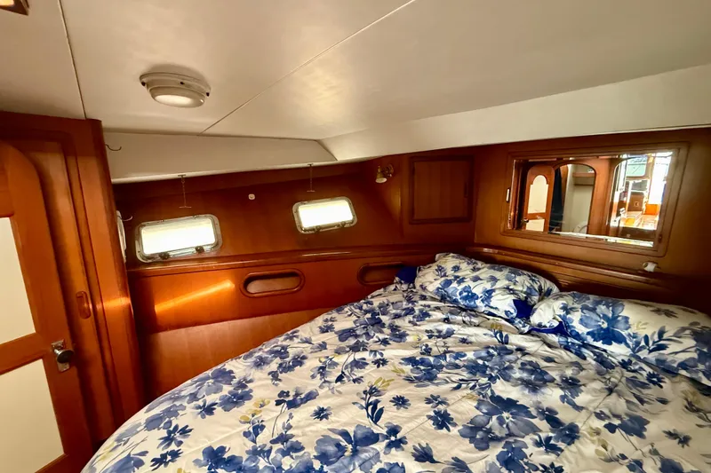 Slide: The Image of Cozy cabin interior of 1990 Mikelson 42 yacht with floral bedding and wooden accents. - 28