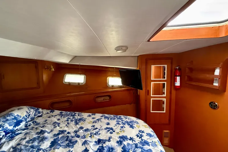 Slide: The Image of Cozy cabin interior of 1990 Mikelson 42 yacht with floral bedding and porthole windows. - 29
