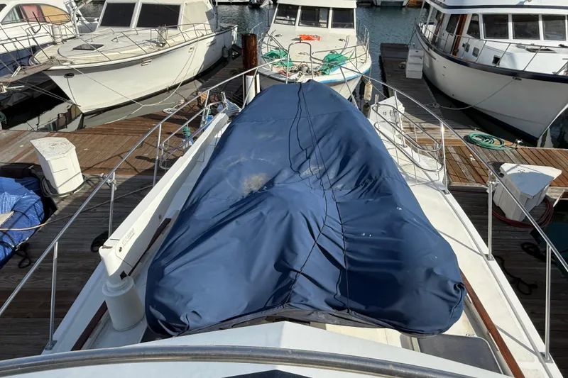 Slide: The Image of Covered 1990 Mikelson 42 yacht docked among other boats at a marina. - 8