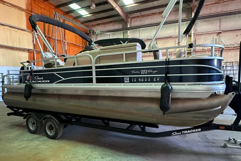 The Image of 2019 Sun Tracker Fishin' Barge 20 DLX pontoon boat in indoor storage. - 0