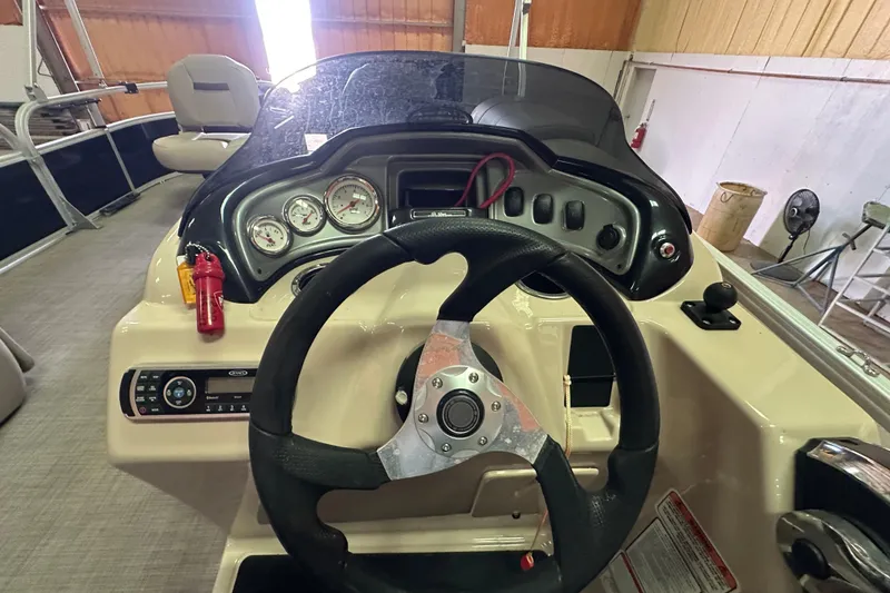 Slide: The Image of 2019 Sun Tracker Fishin' Barge 20 DLX dashboard with steering wheel and gauges. - 12
