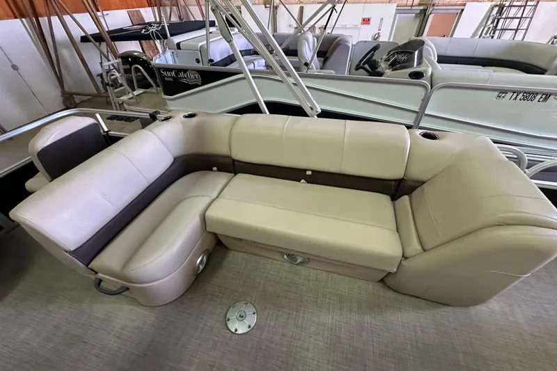 Slide: The Image of 2019 Sun Tracker Fishin' Barge 20 DLX with beige seating in a showroom. - 15