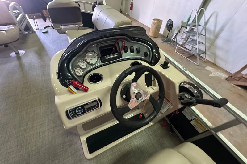Slide: The Image of 2019 Sun Tracker Fishin' Barge 20 DLX dashboard with steering wheel and control panel. - 19