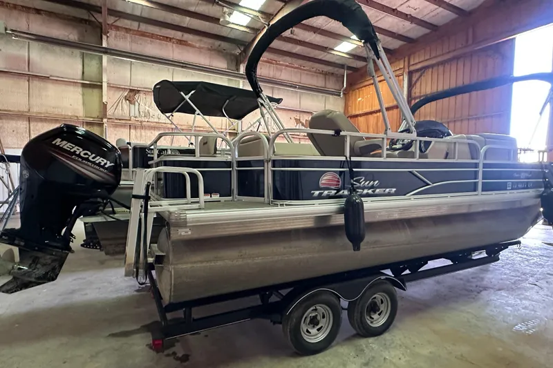 Slide: The Image of 2019 Sun Tracker Fishin' Barge 20 DLX pontoon boat in a warehouse with Mercury engine. - 2