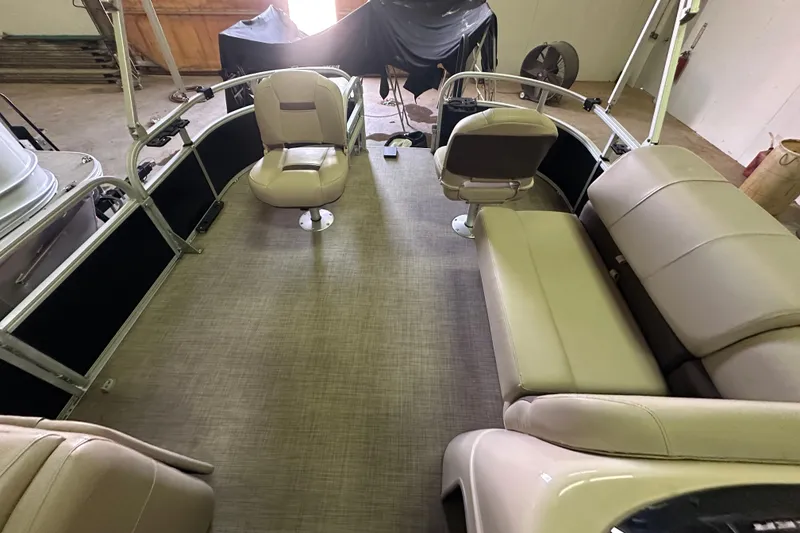 Slide: The Image of 2019 Sun Tracker Fishin' Barge 20 DLX interior with beige seating and spacious layout. - 20