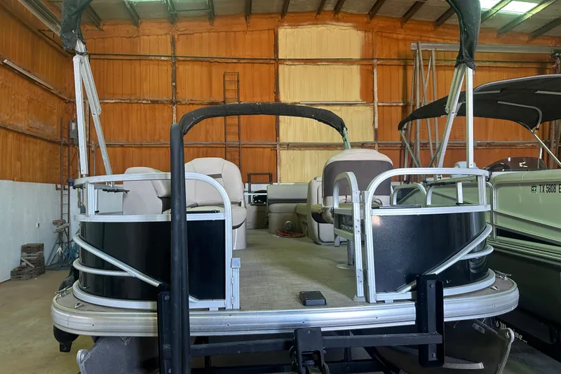 Slide: The Image of 2019 Sun Tracker Fishin' Barge 20 DLX pontoon boat in a storage facility. - 22