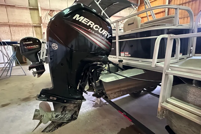 Slide: The Image of 2019 Sun Tracker Fishin' Barge 20 DLX with Mercury outboard motor in a garage. - 3