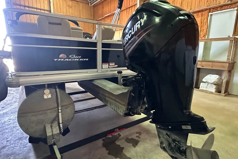 Slide: The Image of 2019 Sun Tracker Fishin' Barge 20 DLX with Mercury outboard motor in a garage. - 4