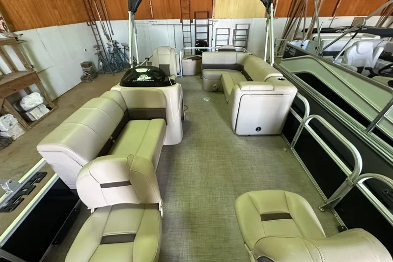 Slide: The Image of 2019 Sun Tracker Fishin' Barge 20 DLX interior with beige seating in a storage area. - 5