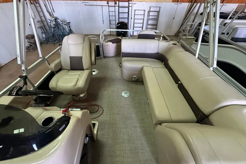 Slide: The Image of 2019 Sun Tracker Fishin' Barge 20 DLX interior with beige seating and steering console. - 7