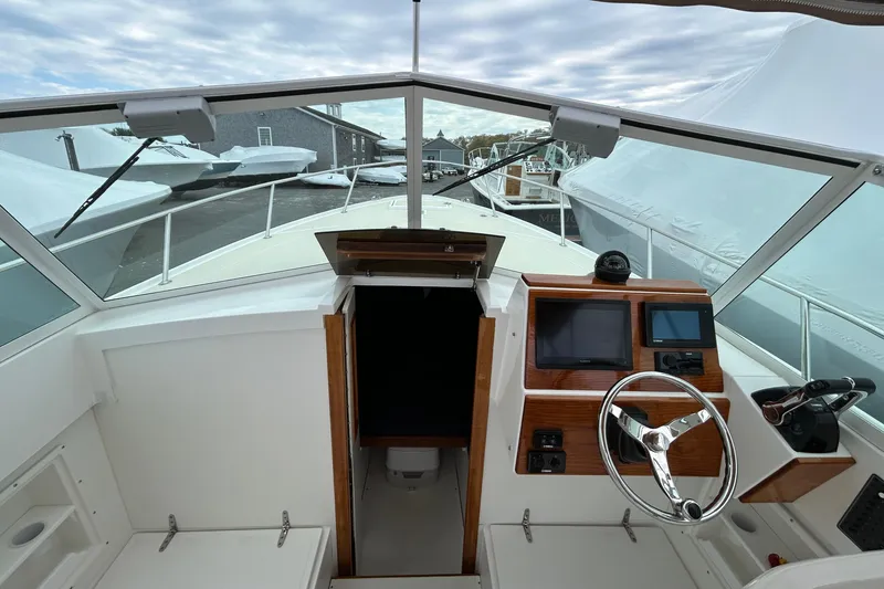 Slide: The Image of Cockpit view of 2019 Limestone 26 boat with steering wheel and navigation screens. - 13