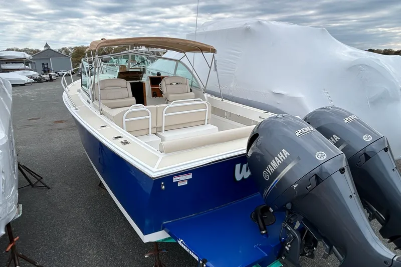 Slide: The Image of 2019 Limestone 26 boat with dual Yamaha 200 engines, docked outdoors. - 17