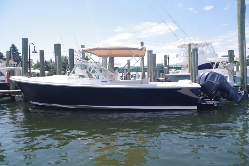 Slide: The Image of 2019 Limestone 26 boat docked, featuring sleek design and powerful outboard motor. - 3