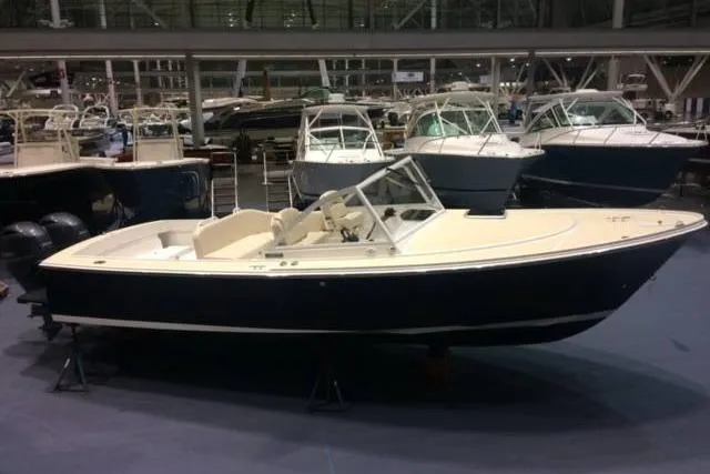 Slide: The Image of 2019 Limestone 26 boat displayed at an indoor boat show, surrounded by other vessels. - 7