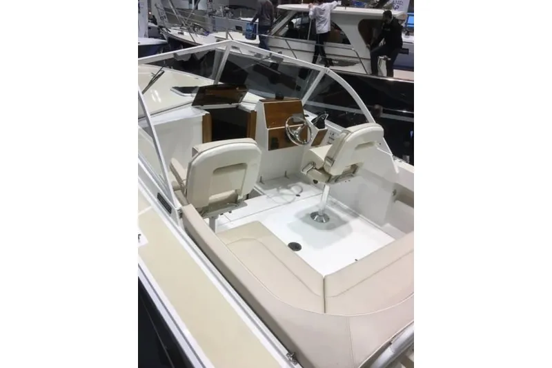 Slide: The Image of 2019 Limestone 26 boat interior with seating and steering wheel at a boat show. - 8