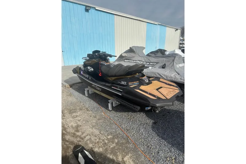 Slide: The Image of 2023 Kawasaki Jetski Ultra 310LX parked outdoors on gravel near a blue building. - 8