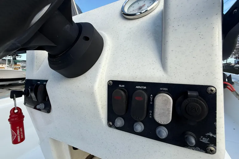 Slide: The Image of 2016 Mako Pro Skiff 17 CC dashboard with switches and gauge. - 16