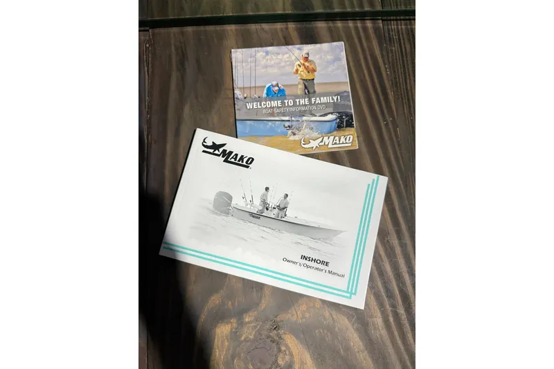 Slide: The Image of 2016 Mako Pro Skiff 17 CC manuals on wooden surface. - 18
