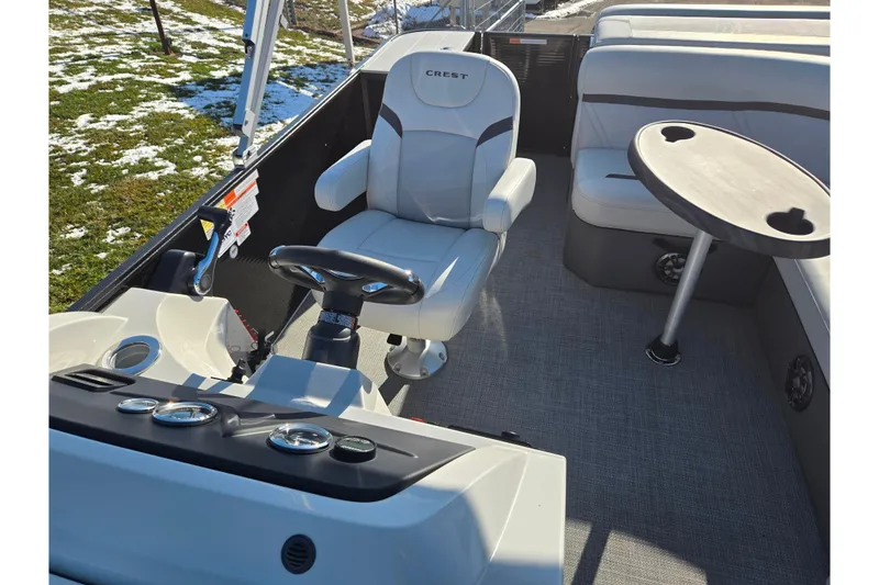 Slide: The Image of 2023 Crest Classic LX 200 boat interior with captain's chair and round table. - 13