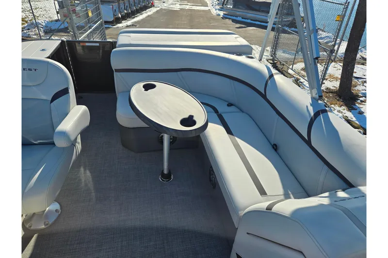 Slide: The Image of 2023 Crest Classic LX 200 pontoon boat interior with gray seating and round table. - 14