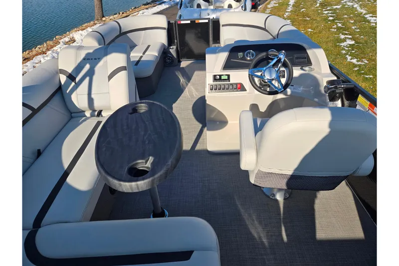 Slide: The Image of 2023 Crest Classic LX 200 pontoon boat interior with seating and steering console. - 20