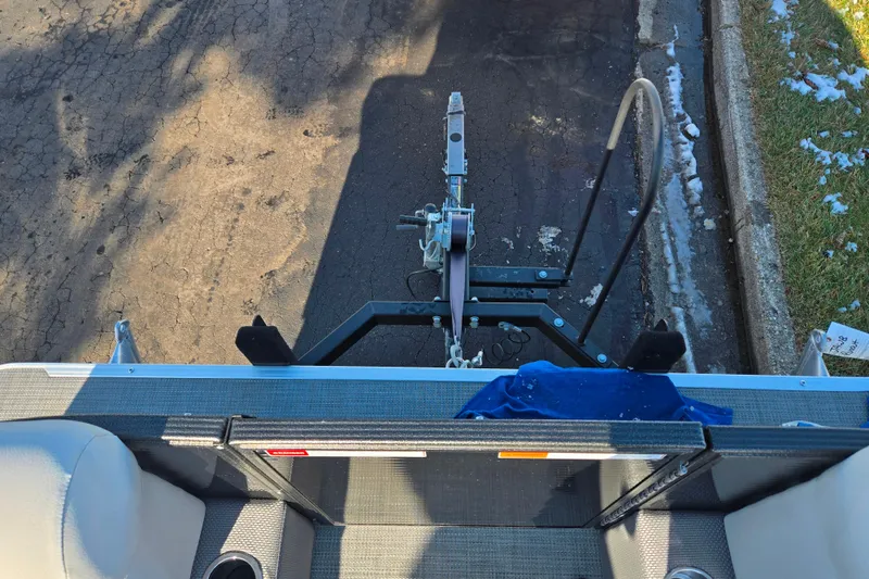 Slide: The Image of 2023 Crest Classic LX 200 boat trailer hitch on asphalt, partial snow on grass. - 24