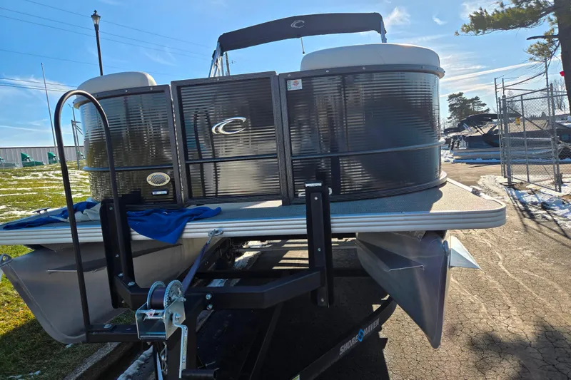 Slide: The Image of 2023 Crest Classic LX 200 pontoon boat on trailer, parked outdoors. - 6