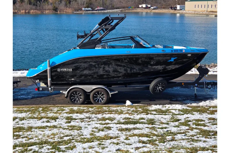 The Image of 2023 Yamaha Boats 222XD on trailer by a lake in winter setting. - 0