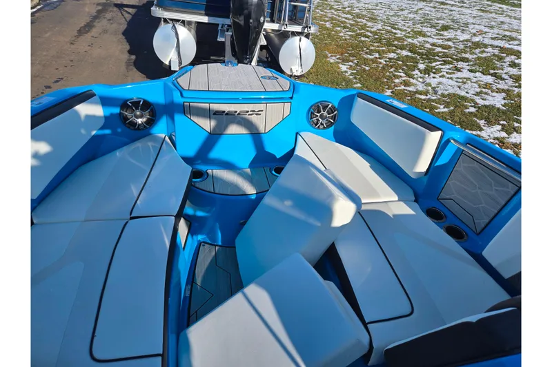 Slide: The Image of 2023 Yamaha Boats 222XD interior with blue and white seating, speakers, and cup holders. - 20
