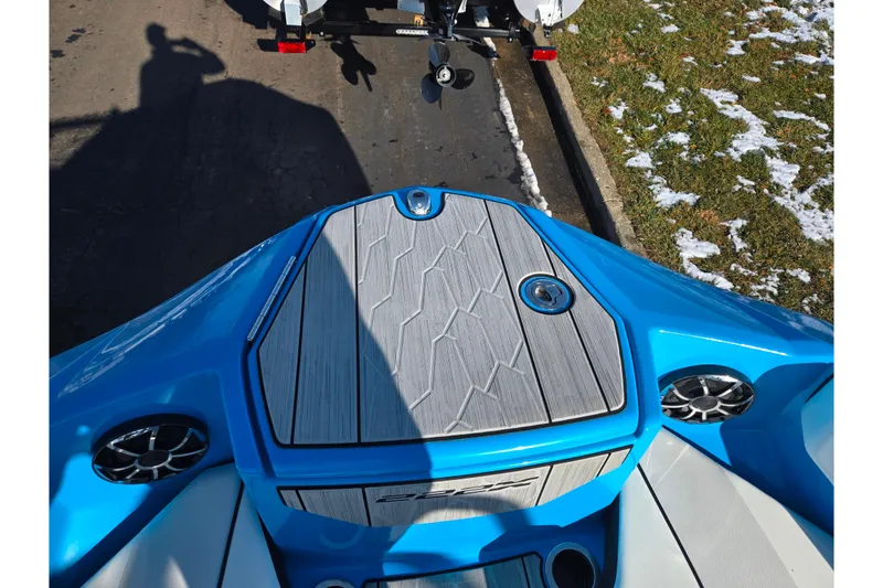 Slide: The Image of 2023 Yamaha Boats 222XD bow with blue accents and speakers, parked on a snowy street. - 21