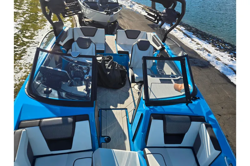Slide: The Image of 2023 Yamaha Boats 222XD, blue exterior, docked by a snowy lakeside. - 23