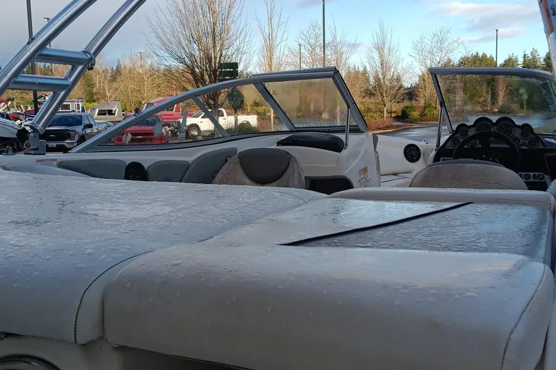 Slide: The Image of 2013 Bayliner 215 Bowrider boat interior with wet seats and dashboard, outdoors. - 8