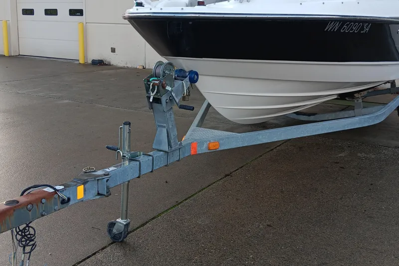 Slide: The Image of 2013 Bayliner 215 Bowrider interior with worn white seating and visible wear. - 9