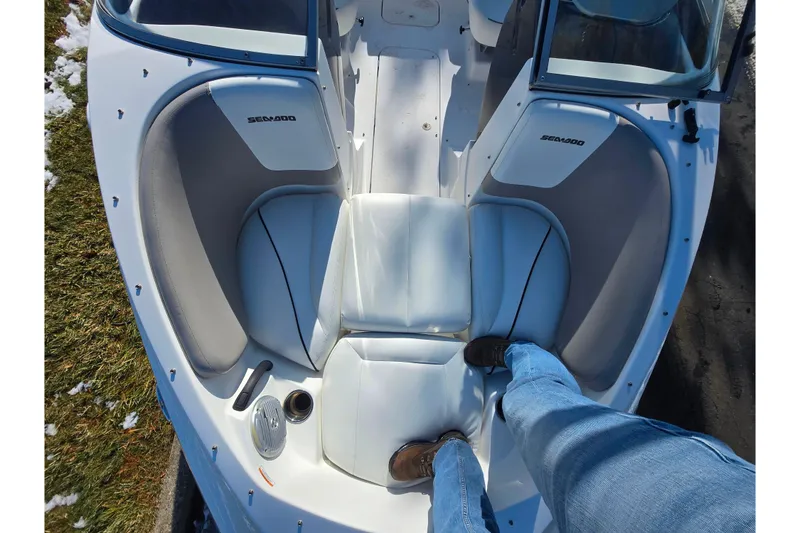 Slide: The Image of 2011 Sea-Doo 180 Challenger SE boat interior with person standing, showcasing seating and design. - 19