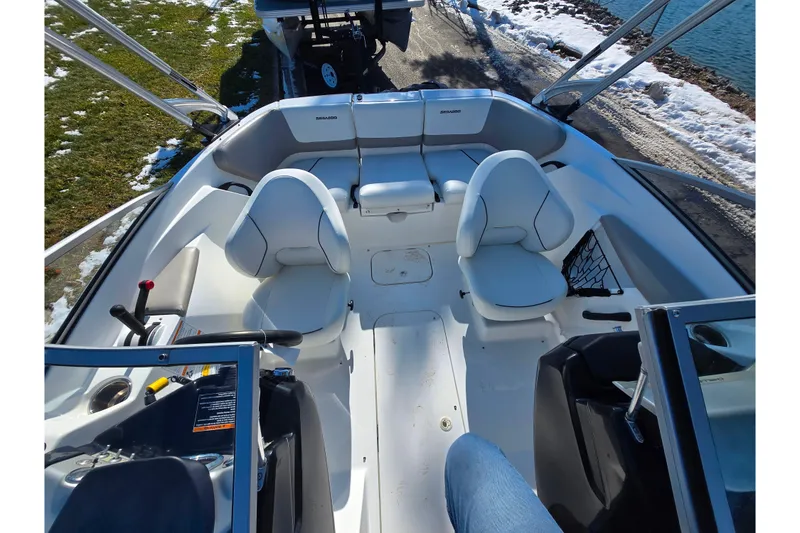 Slide: The Image of 2011 Sea-Doo 180 Challenger SE interior with seating and controls, docked by a snowy shore. - 21