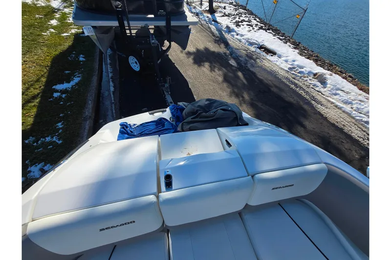 Slide: The Image of 2011 Sea-Doo 180 Challenger SE boat on trailer by snowy lakeside road. - 24