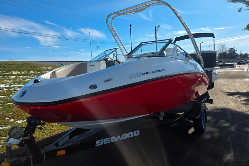 Slide: The Image of 2011 Sea-Doo 180 Challenger SE boat on trailer, red and white design, sunny day. - 5
