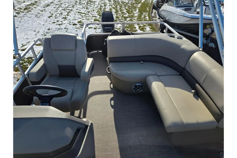 Slide: The Image of 2025 Sun Tracker Party Barge 18 DLX interior with plush seating and steering console. - 13