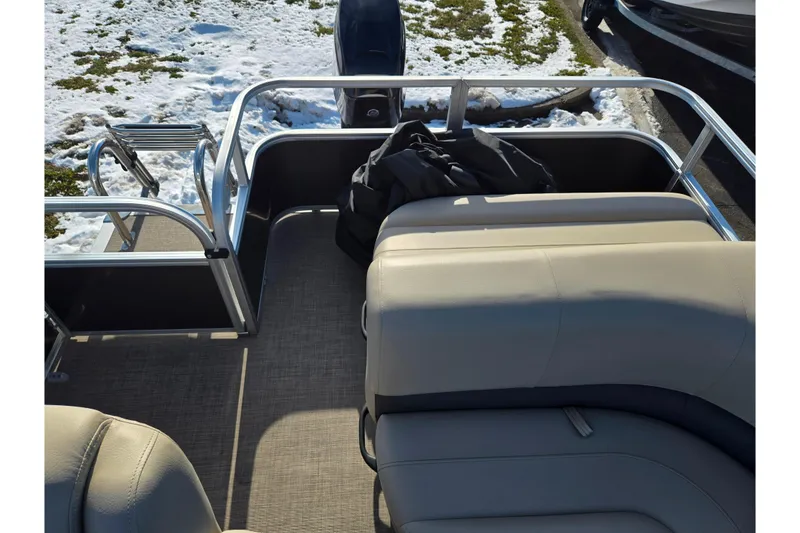Slide: The Image of 2025 Sun Tracker Party Barge 18 DLX interior with seating and snow-covered ground. - 15