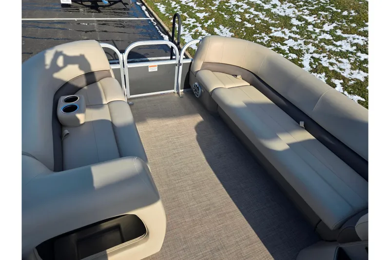 Slide: The Image of 2025 Sun Tracker Party Barge 18 DLX interior with beige seating and cup holders. - 21