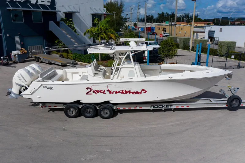Slide: The Image of 2022 SeaVee 370Z boat on trailer, parked outdoors near industrial buildings. - 3