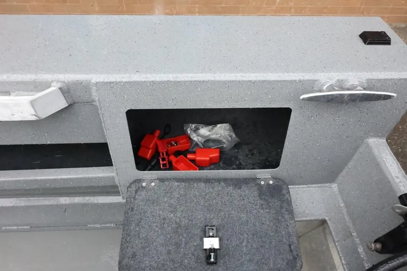 Slide: The Image of 2025 Thunder Jet 209 Rush OT boat storage compartment with red accessories inside. - 23