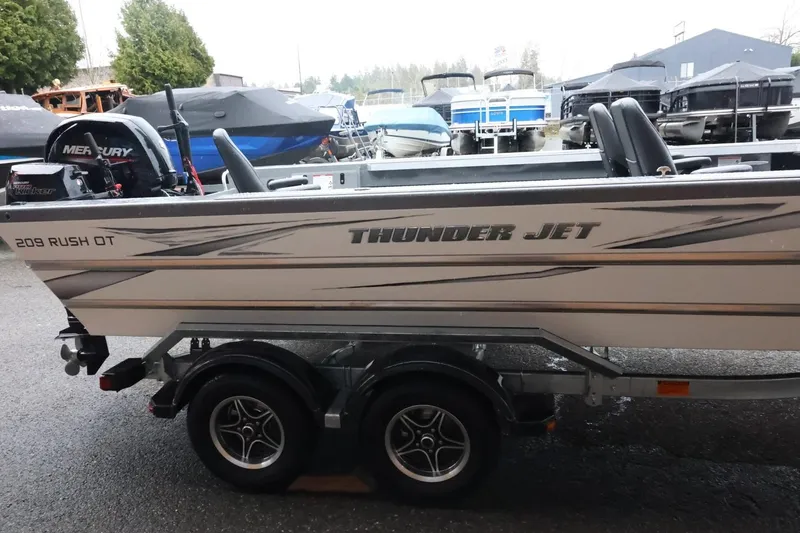 Slide: The Image of 2025 Thunder Jet 209 Rush OT boat on trailer, featuring Mercury outboard motor. - 5